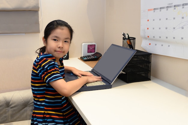 Petite fille asiatique avec ordinateur portable. concept de l'éducation.