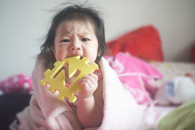 Une petite fille asiatique pique des jouets colorés.