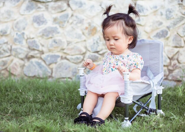 Petite fille assise sur une chaise de pique-nique dans le parc en été vacances en plein air Belle fille jolie fille voyage camping dans le jardin Image de jolie petite fille