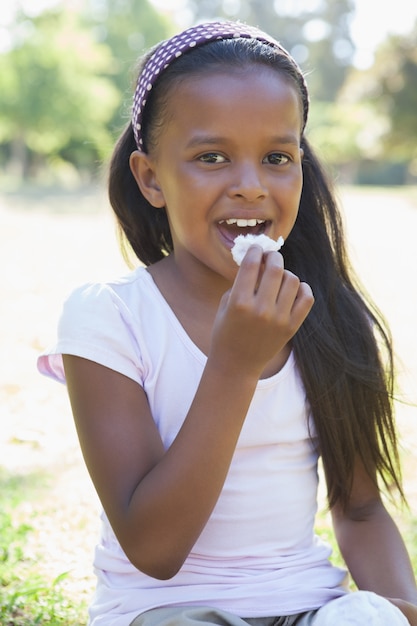 Petite fille assise sur l&#39;herbe