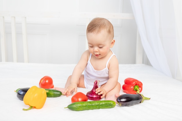 Petite fille assise sur le lit avec des légumes