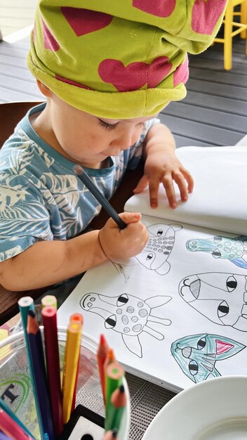 Petite fille assise à la table et dessinant