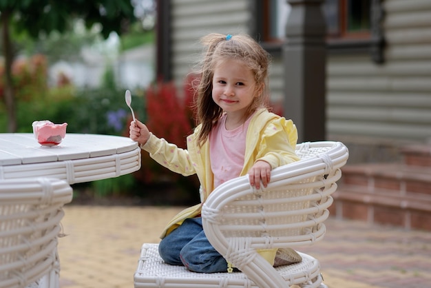 Photo une petite fille assise à une table avec une fourchette à la main