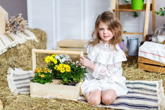 Une petite fille assise et tenant de belles fleurs