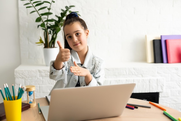 Petite fille assistant à la classe de plate-forme d'apprentissage en ligne depuis la maison alors que l'école a été fermée pendant l'épidémie de coronavirus.