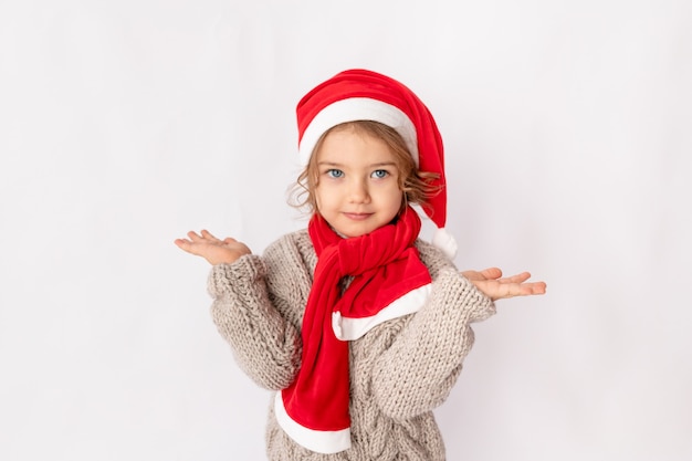 Petite fille au bonnet de Noel sur fond blanc, espace pour le texte