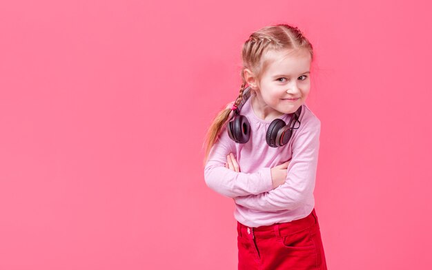 Petite fille au casque sur fond rose