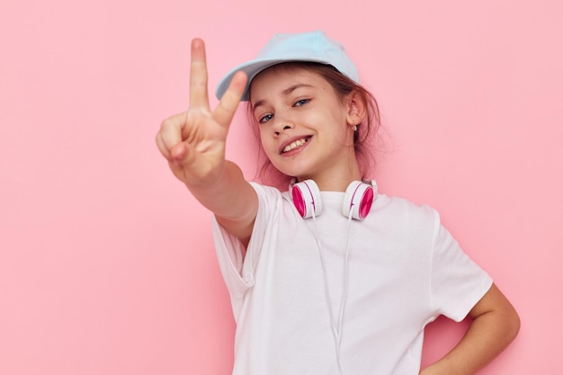 Petite fille au casque posant sur fond rose