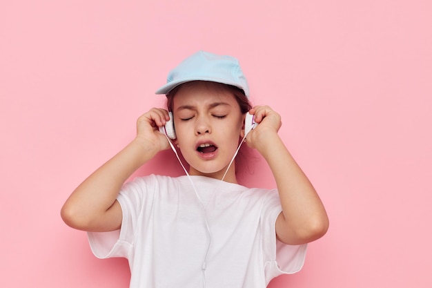 Petite fille au casque posant sur fond rose