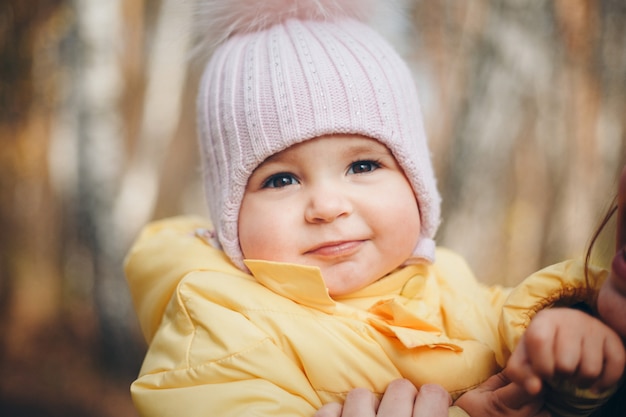 Une Petite Fille Au Chapeau Chaud Sur La Tête Sourit. Le Concept De L'enfance, La Santé, La Fiv, Le Temps Froid