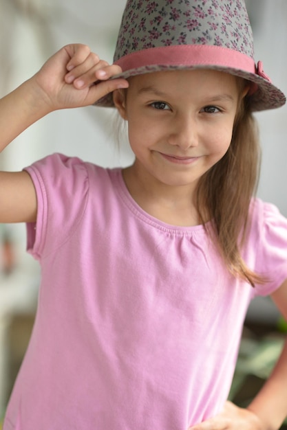 Petite fille au chapeau posant