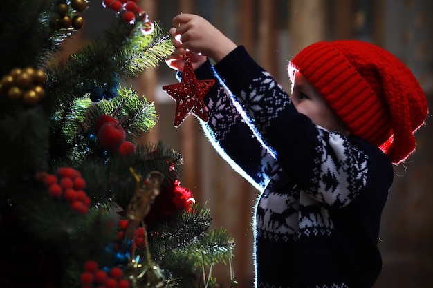 Petite fille au chapeau rouge en attente du père noël. Joyeux et lumineux Noël. Beau bébé profite de Noël. Santa girl petit enfant fête Noël à la maison.