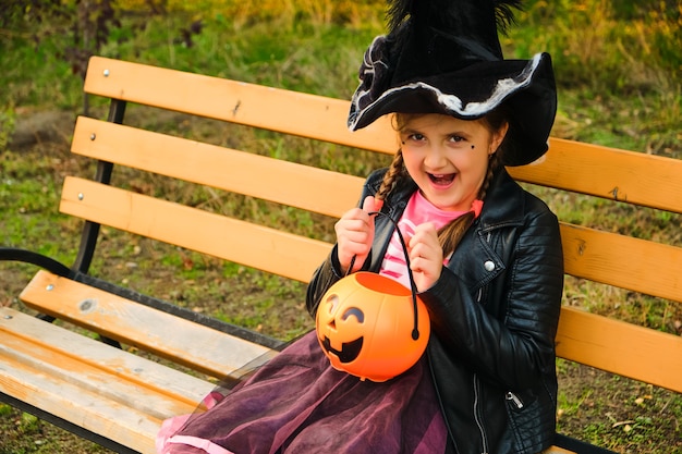 Petite fille au chapeau de sorcière dans le parc de l'automne.