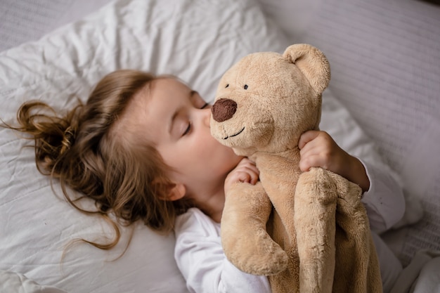 petite fille au lit avec peluche les émotions d'un enfant