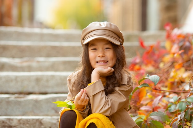 Une petite fille en automne sur les marches