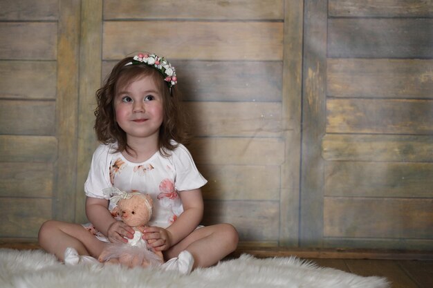 Petite fille aux cheveux bouclés, s'amusant en posant devant la caméra