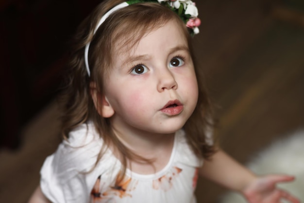 Petite fille aux cheveux bouclés, s'amusant en posant devant la caméra