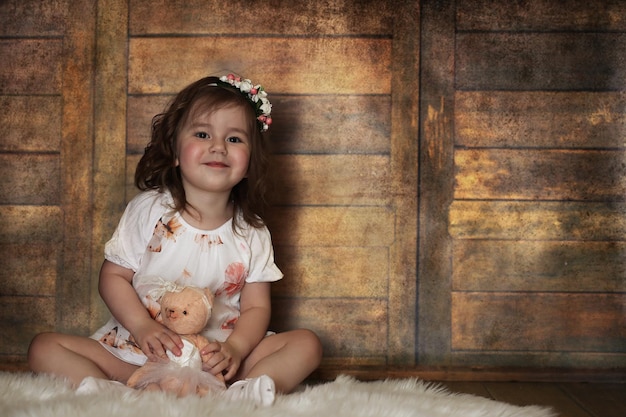 Petite fille aux cheveux bouclés, s'amusant en posant devant la caméra