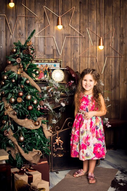 petite fille aux cheveux longs, décorer le sapin de Noël.