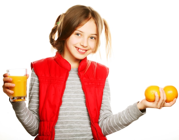 Petite fille aux oranges et jus. Isolé sur blanc.