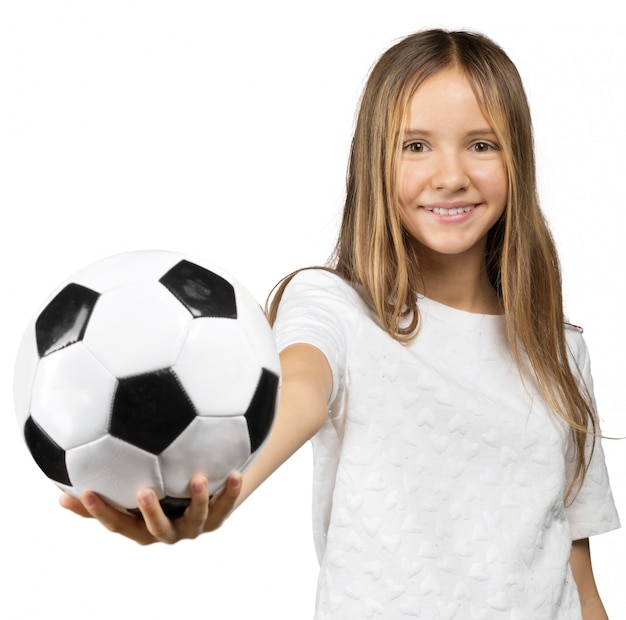 Petite fille avec un ballon de foot isolé sur un fond blanc