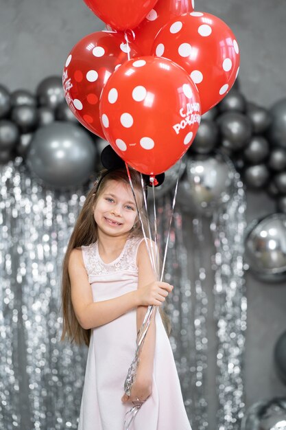 Petite fille avec des ballons fête son anniversaire