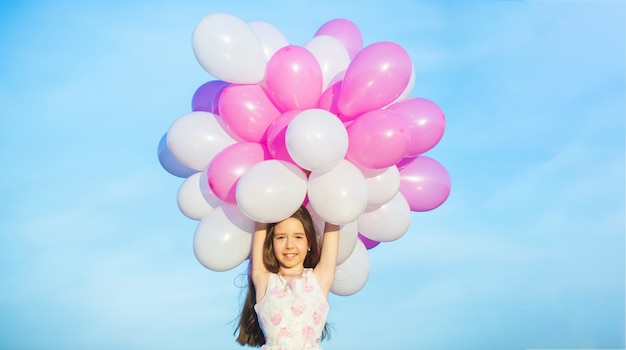 Petite fille avec des ballons. Vacances d'été, célébration, enfants petite fille heureuse avec des ballons colorés.