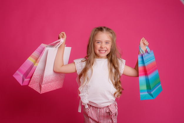 Une petite fille avec beaucoup de sacs à provisions