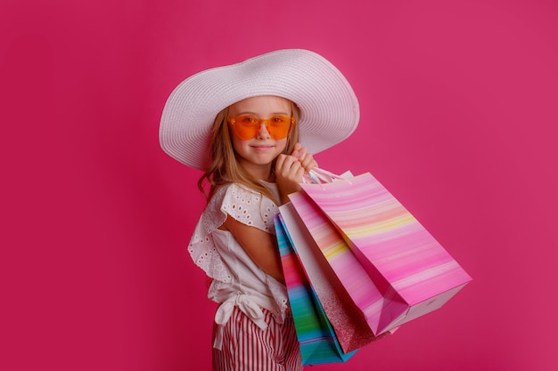 Une petite fille avec beaucoup de sacs à provisions