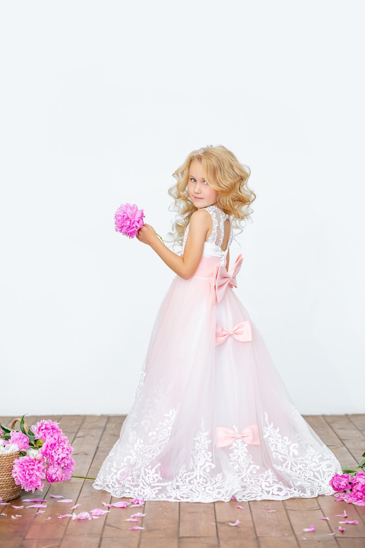 Photo petite fille belle enfant en robe de luxe avec des pivoines en surface blanche intérieure