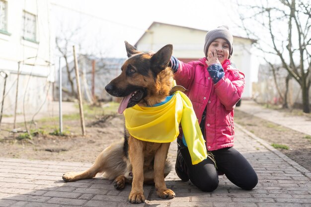 Petite fille et berger allemand avec le drapeau de l'Ukraine.