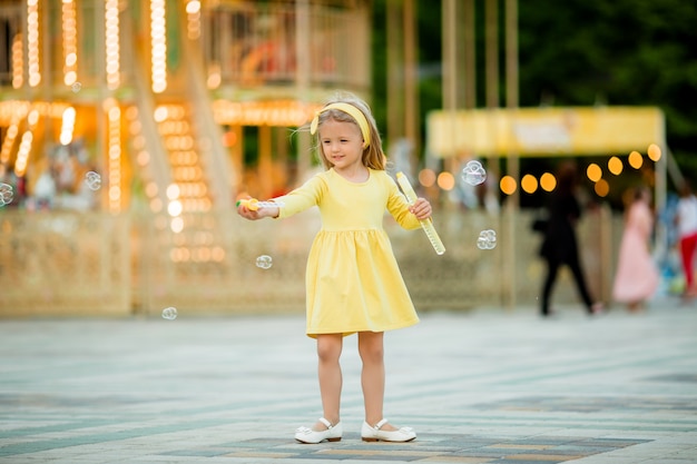 petite fille blonde au parc d'attractions