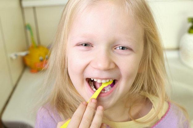 Petite fille blonde avec brosse à dents