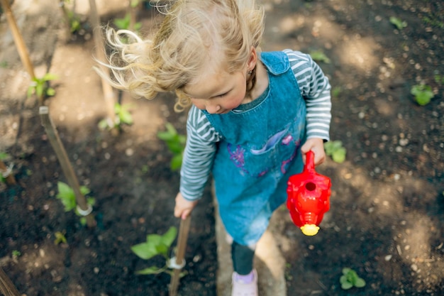 Petite fille blonde jardinage