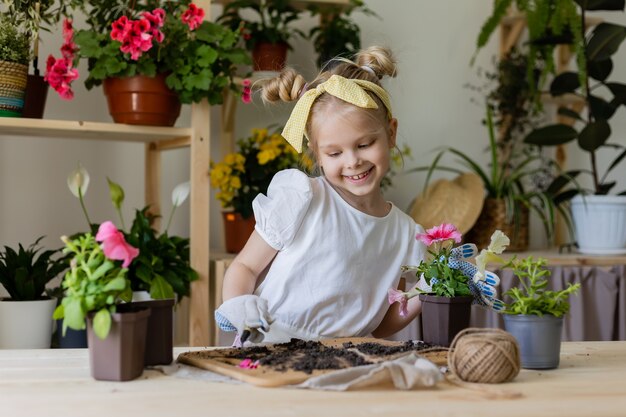 petite fille blonde plantes et greffes eaux fleurs d'intérieur Petite aide aux tâches ménagères