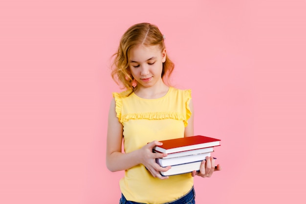 petite fille blonde posant avec des cahiers