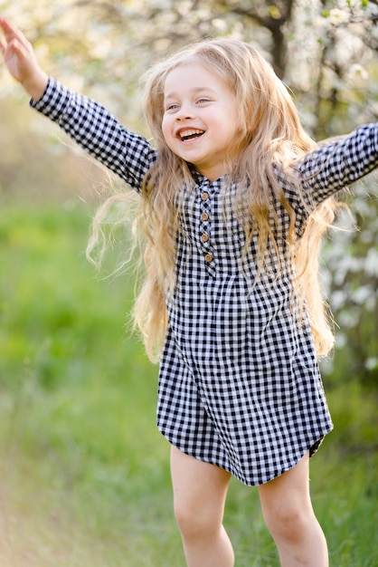 Petite fille blonde s'amusant dans le parc du printemps.