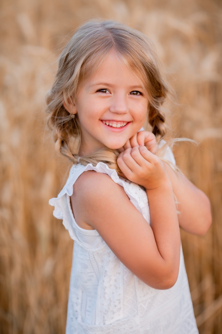 Photo petite fille blonde se promène dans un champ de blé d'été