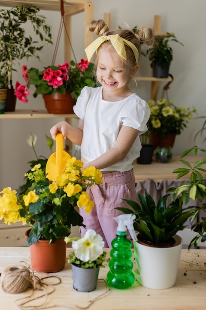 Petite fille blonde sprays ou eaux fleurs d'intérieur accueil jardinage enfant aide ménagère