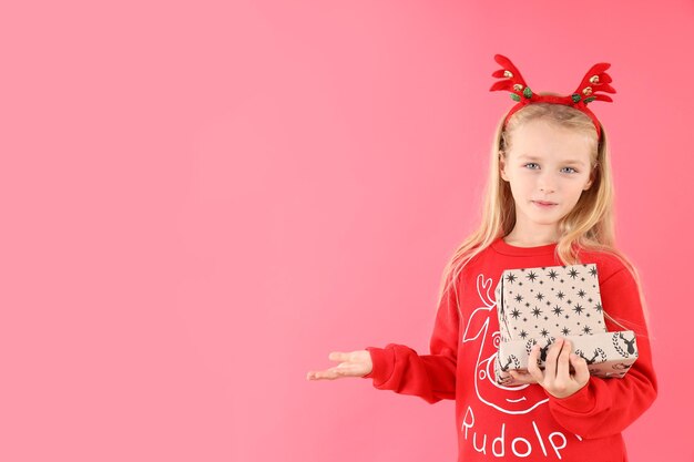 Petite fille avec des boîtes de Noël sur fond rose