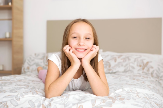 Petite fille de bonne humeur en pyjama dans la chambre