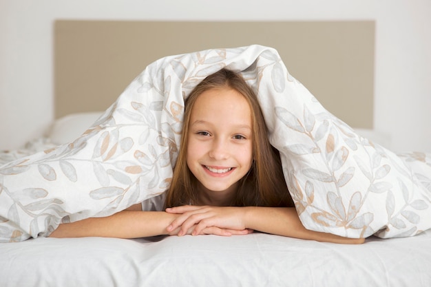 Petite fille de bonne humeur en pyjama dans la chambre