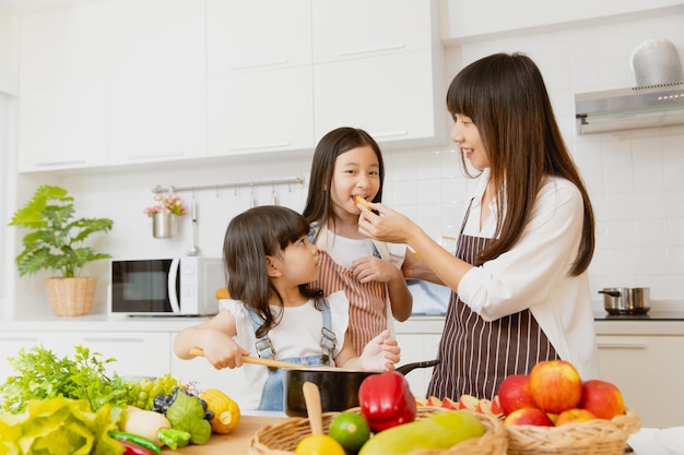 Petite fille en bonne santé, manger des fruits et jouer à la cuisine avec maman à la maison cuisine salle