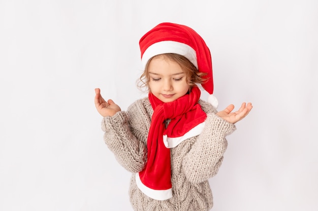 Petite fille en bonnet de Noel sur fond blanc, espace pour le texte