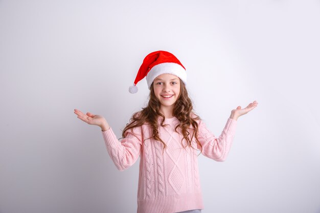 petite fille en bonnet de noel souriant sur fond blanc