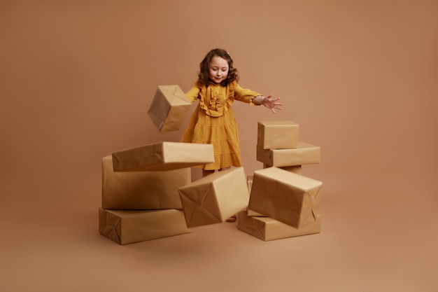 Petite fille bouclée avec grosse pile de cadeaux pour les vacances