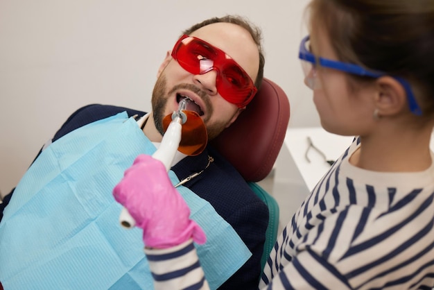 Une petite fille bouclée et son père jouent une relation heureuse de dentiste