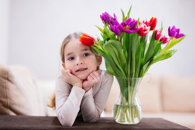 Petite fille avec bouquet de tulipes printanières Décor de vacances avec fleurs tulipes colorées