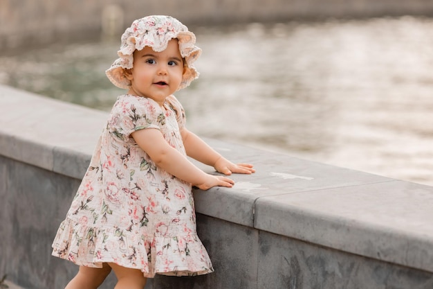 petite fille brune vêtue d'une robe en coton en été lors d'une promenade