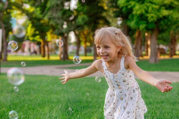 petite fille et bulles de savon dans le parc